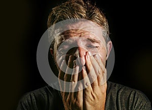 Young sad and devastated man crying desperate covering face with his hands feeling stressed and lost suffering pain and depression