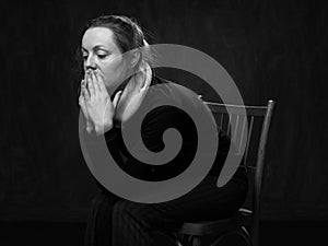 Young sad disoriented woman sitting on the chair photo