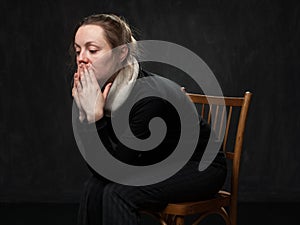Young sad disoriented woman sitting on the chair photo