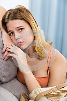 sad female on cozy sofa at home