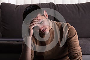 Sad Man Sitting In Front Of Sofa