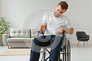 Young sad man in a wheelchair at home.