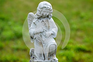 Young sad stone angel praying