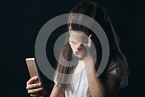 Young sad vulnerable girl using mobile phone scared and desperate suffering online abuse cyberbullying being stalked