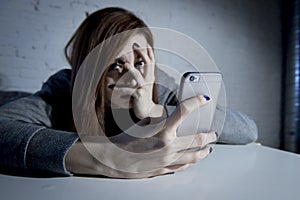 Young sad vulnerable girl using mobile phone scared and desperate suffering online abuse cyberbullying