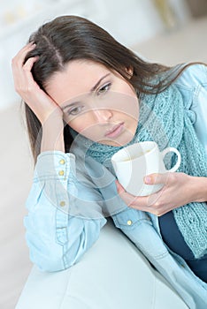 Young sad woman with cup coffee or tea