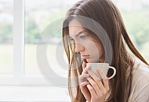 Young woman with cup of coffee or tea