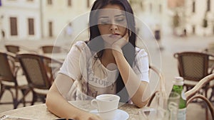 Young sad woman having coffee at restaurant in HD VIDEO