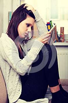 Young sad woman sitting in children room