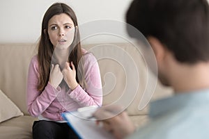 Young sad woman telling about her problem to male psychotherapis