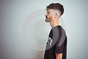 Young safeguard man with tattoo wering security uniform over isolated white background looking to side, relax profile pose with