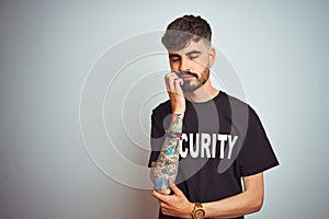 Young safeguard man with tattoo wering security uniform over isolated white background thinking looking tired and bored with