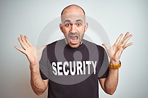 Young safeguard man wearing security uniform over isolated background celebrating crazy and amazed for success with arms raised