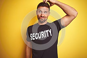 Young safeguard man wearing security uniform over yellow isolated background confuse and wonder about question