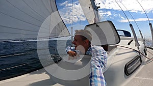 Young sailor alone recording selfie from Sailboat's bow in open sea. Travel, adventure concept