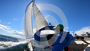 Young sailor recording selfie from Sailboat in wavy, open sea. Travel, adventure concept