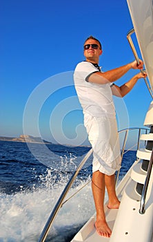 Young Sailor relaxing happily on the vacation sailboat yach