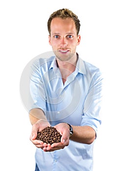 Young salesman showing hands full with coffee beans