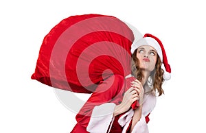 Young Santa`s girl carries a huge red heavy red bag with gifts, isolated on white background.