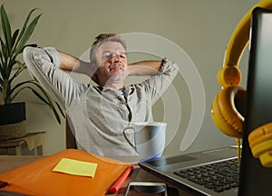 Young satisfied and confident business man leaning on chair relaxed working at home office with laptop computer sitting on desk sm