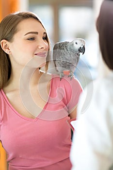 Young satisfied girl listening diagnosis of veterinarian in vet