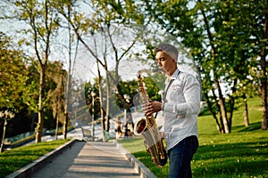 Young saxophonist plays the saxophone in park