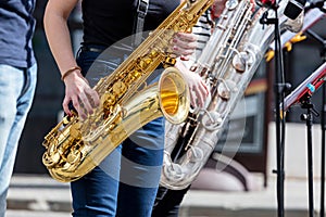 Young saxophonists playing saxes during street performance