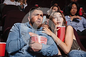 Young scared couple watching a horror movie