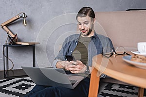 young sceptic man looking at laptop while sitting