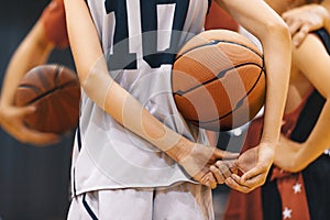 Young School Boy Holding Basketball Ball and Listening To Coach at Training Game. Junior Basketball Players in Practice Game