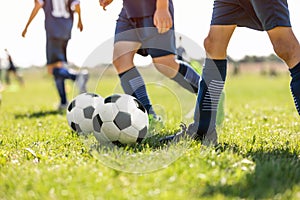 Young School Footballers Dribbling Around Cones in Drill on a Sunny Day