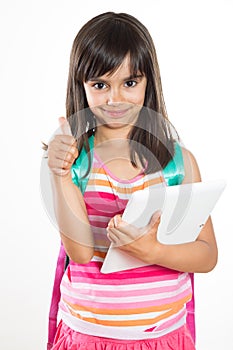 Young school girl with a tablet and schoolbag showing thumbs up