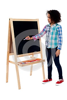 Young school girl writing on blackboard