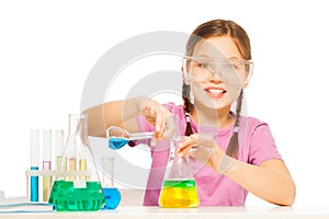 Young schoolgirl mixing blue and yellow reactants photo
