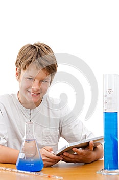 Young science student with tablet doing homework.