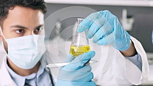 Young scientist analyzing scientific experimental fluid for a covid cure in a lab. Medical professional using science