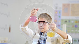 Young scientist compares two colorful liquids in laboratory