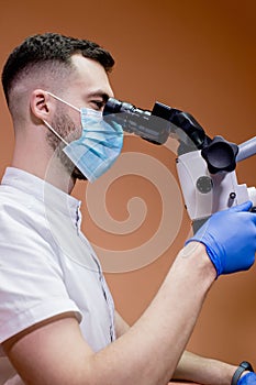 A young scientist conducting research with a microscope. Working with a microscope