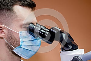 A young scientist conducting research with a microscope. Working with a microscope