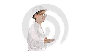 Young scientist in lab coat and hardhat walking and saying somet