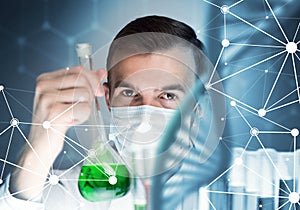 Young scientist mixing reagents in glass flask in clinical laboratory