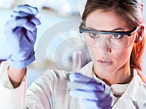 Young scientist pipetting in life science laboratory.