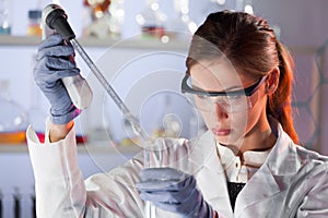 Young scientist pipetting in life science laboratory.