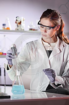 Young scientist pipetting in life science laboratory.