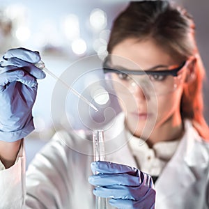 Young scientist pipetting in life science laboratory.