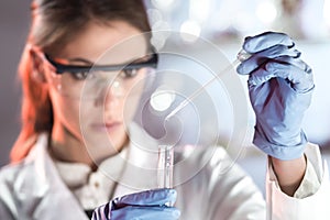 Young scientist pipetting in life science laboratory.