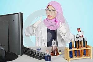 Young scientist showing thumb up at camera