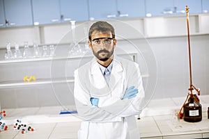 Young scientist in white lab coat standing in the biomedical lab