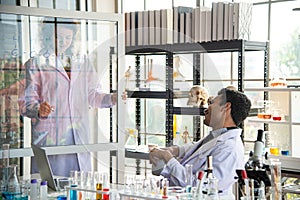 Young scientists or researchers doing chemical research in laboratory. Scientist working on computer and laboratory equipment
