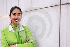 Young scort woman or crew smiling crossed arms green